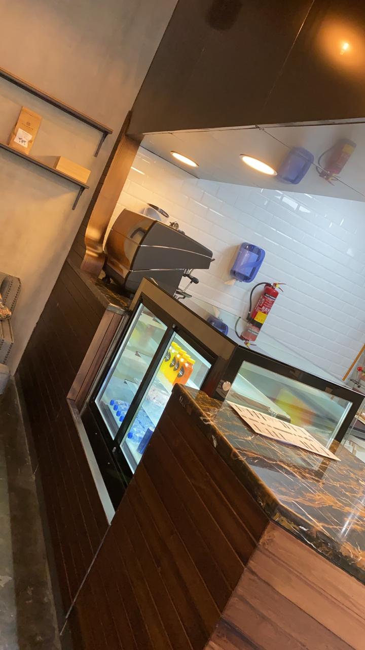 Modern coffee counter interior with marble top and wooden design – ARC Design Dubai