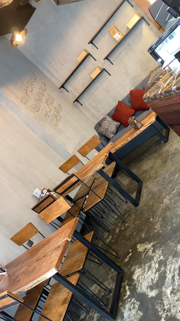 Modern café interior design with wooden tables, industrial chairs, and cozy seating – ARC Design Dubai