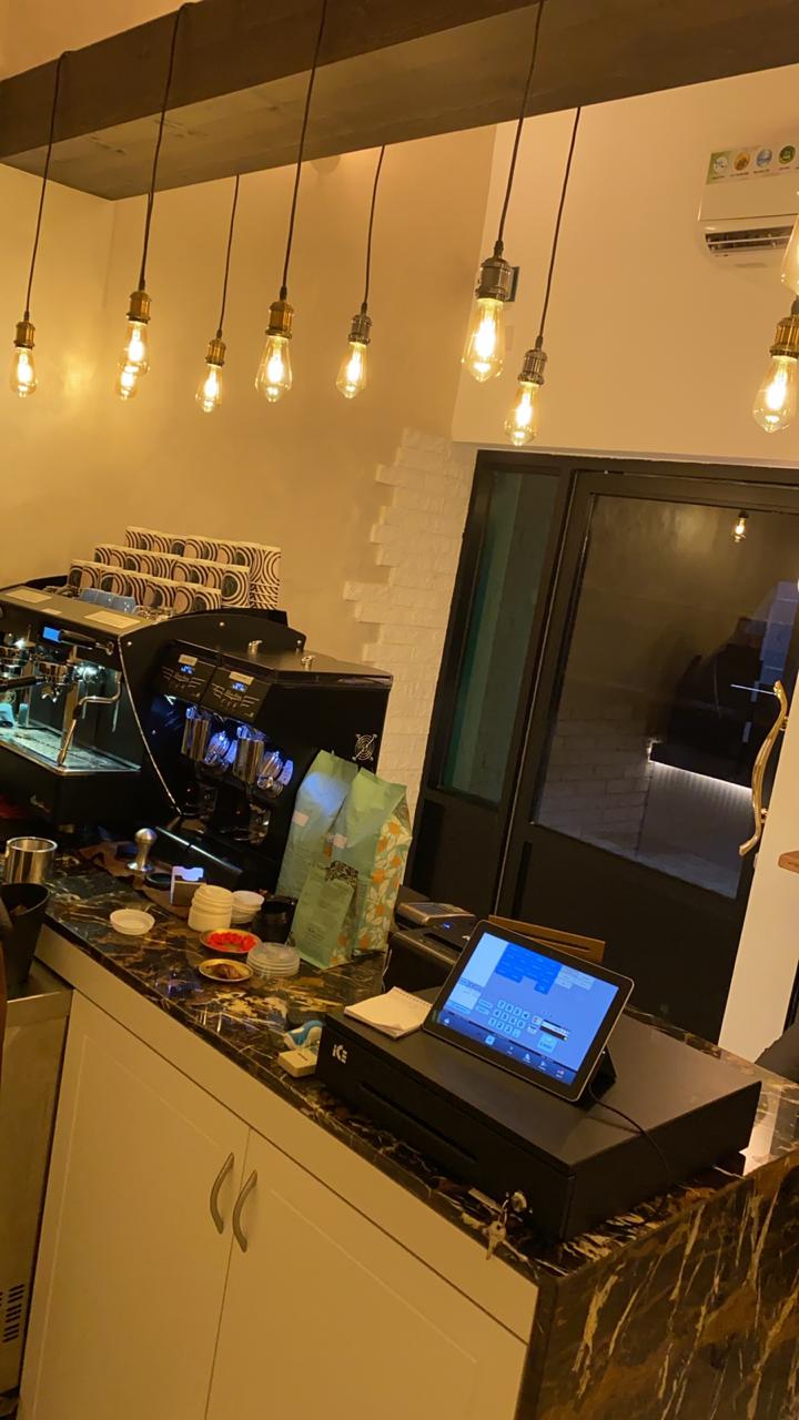 ARC Design café counter with espresso machine and modern hanging lights in Dubai