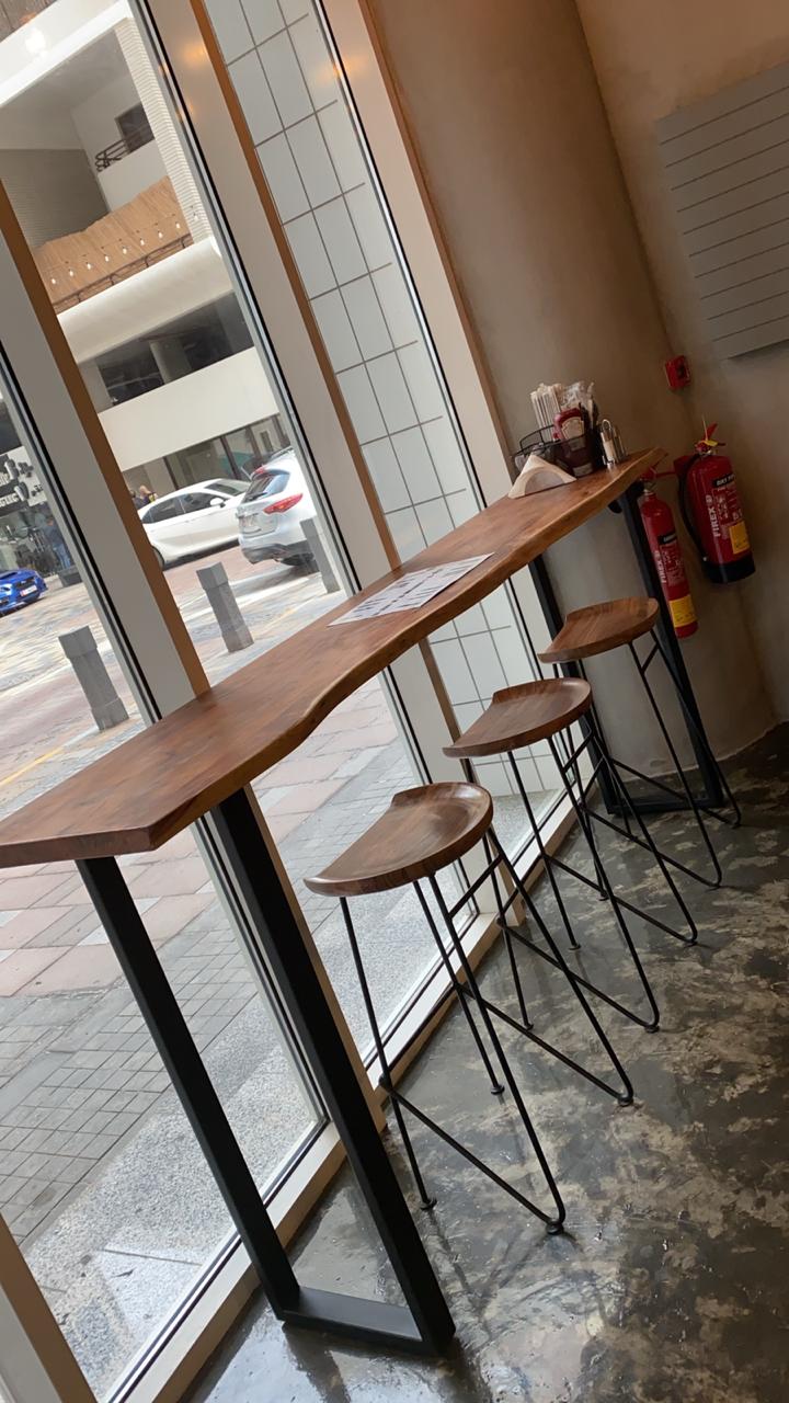ARC Design high table and stools interior at Fateraty café Dubai with natural wood and industrial style